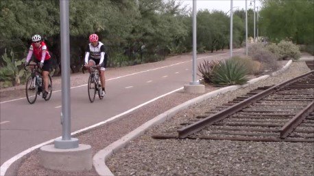 Two people cycling on a bike path.