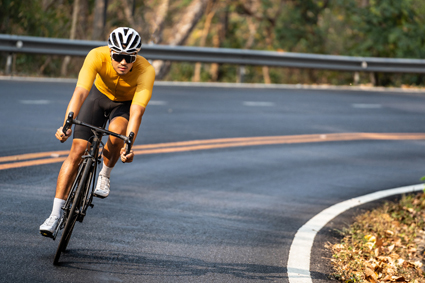 Man cycling very fast on a windy road.