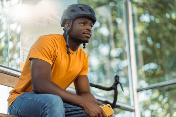A cyclist rests at a bus stop.