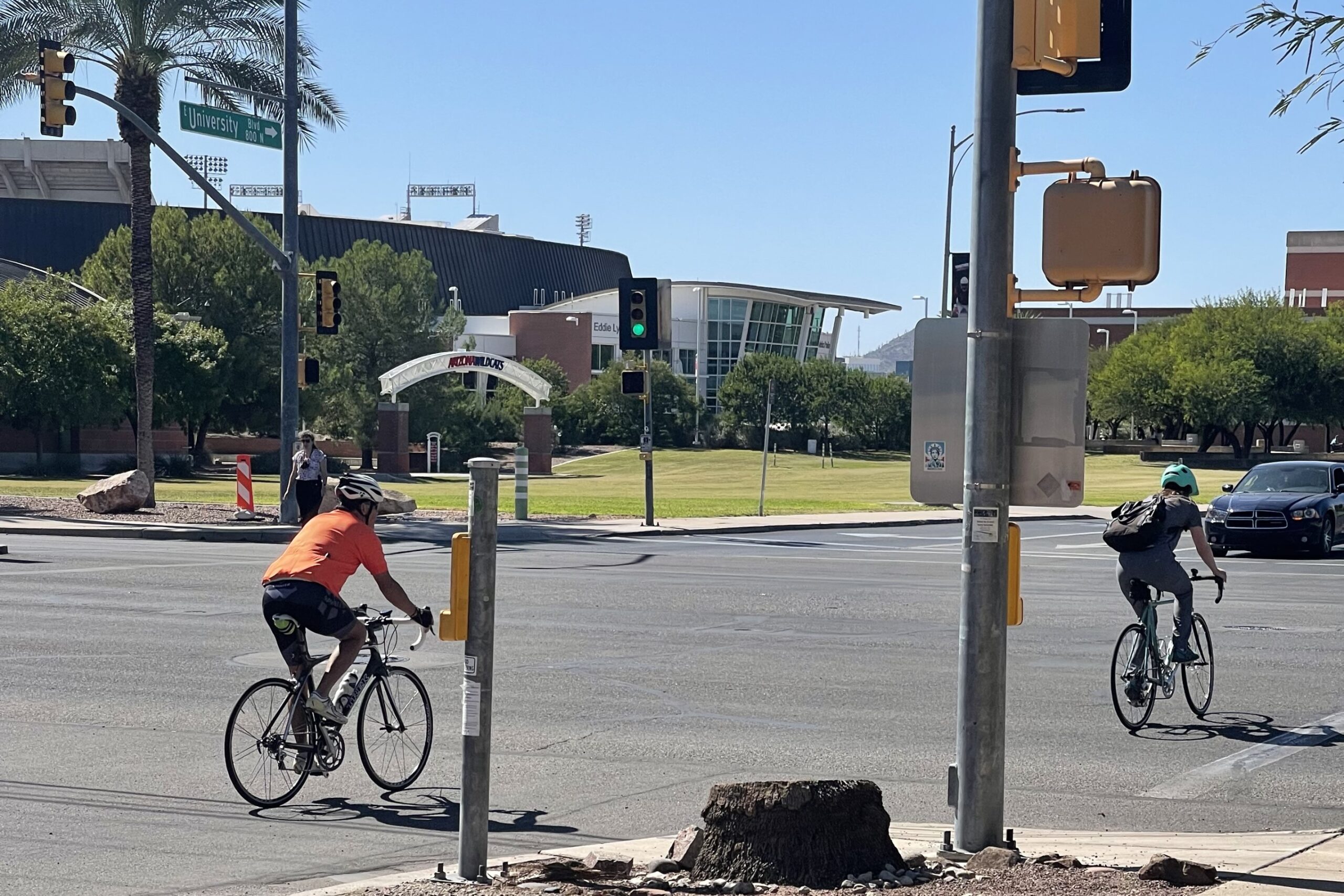 Cyclists cross the road near the University of Arizona campus.