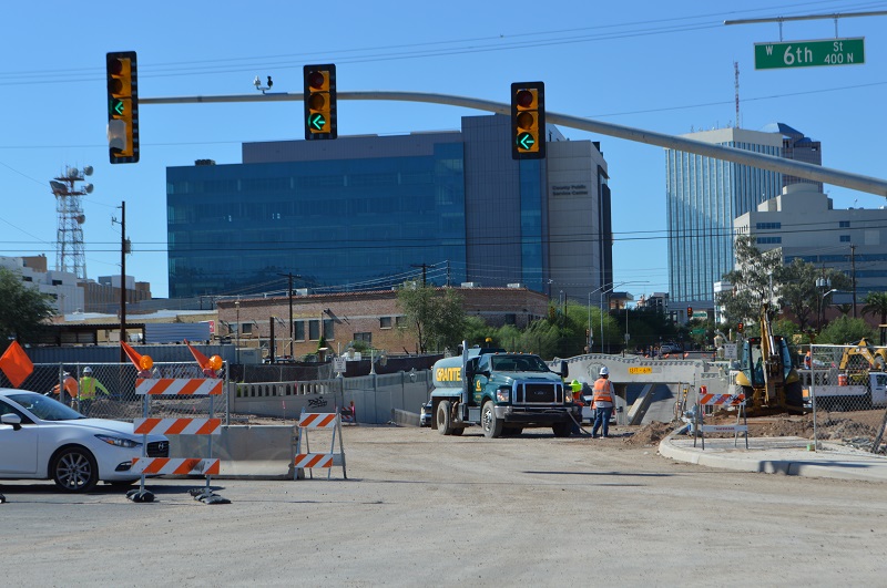 Construction workers and construction vehicles working at Stone Ave and 6th Street in downtown Tucson.